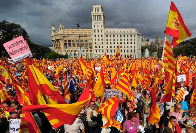 Anti-independentist Catalans hold Catalan and Spanish flags during a demonstration at Catalunya square on October 12, 2012 in Barcelona.    AFP PHOTO/ LLUIS GENE SPAIN-CATALONIA-PROTEST