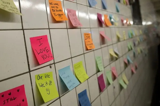 NEW YORK, NY - NOVEMBER 10: Post-it notes, many with politically themed messages, hang on a wall at the 6th Avenue subway station as part of a public art project entitled 'Subway Therapy,' November 10, 2016 in New York City. Artist Matthew Chavez, who goes by 'Levee,' created the 'Subway Therapy' wall to offer New Yorkers a chance to write down their feelings in the wake of the presidential election. Drew Angerer/Getty Images/AFP